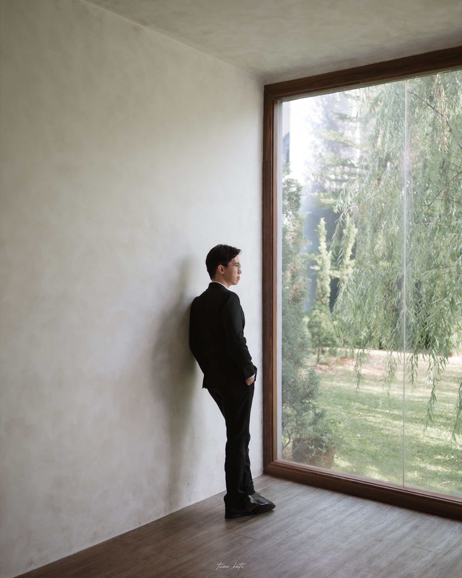 Anthony William Chandra standing beside a large window